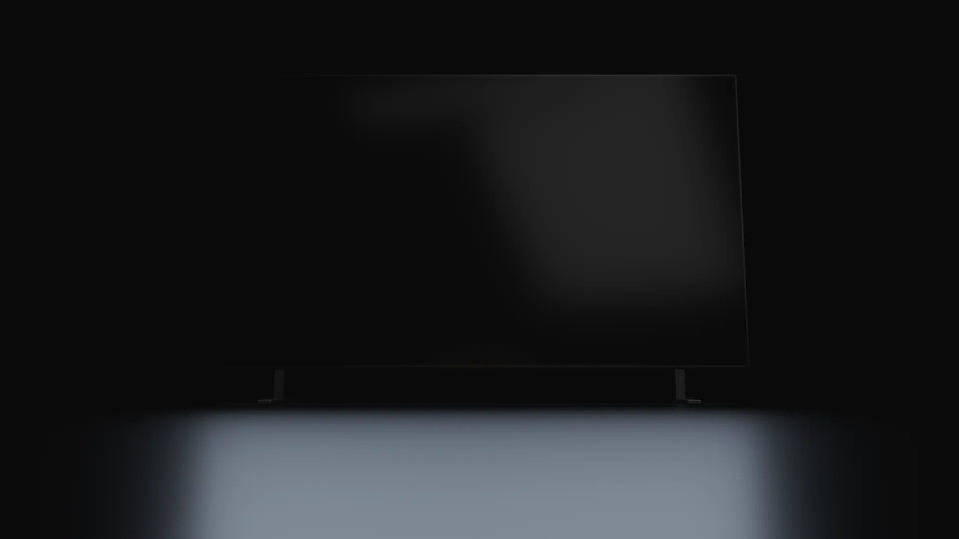 A dark stage with a large projector screen behind Spot